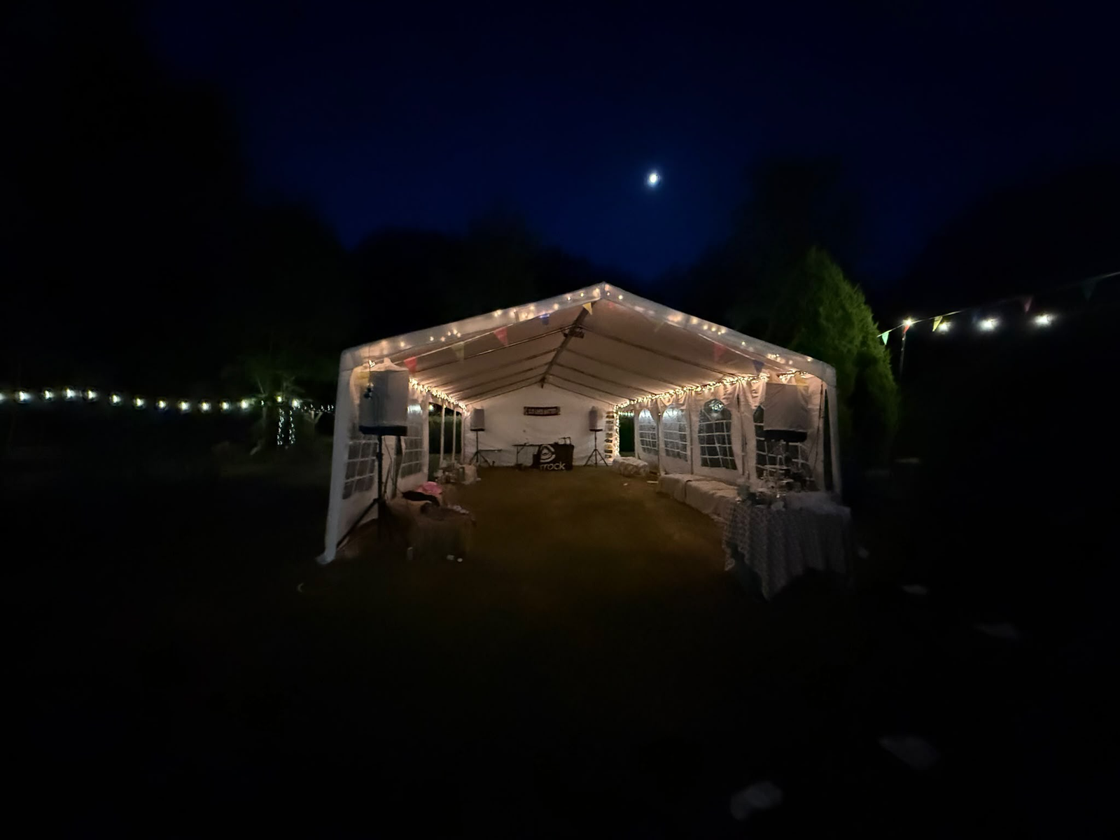 20m clear-span marquee with ivory lining and festoon lighting, set up for a wedding reception in Horsham