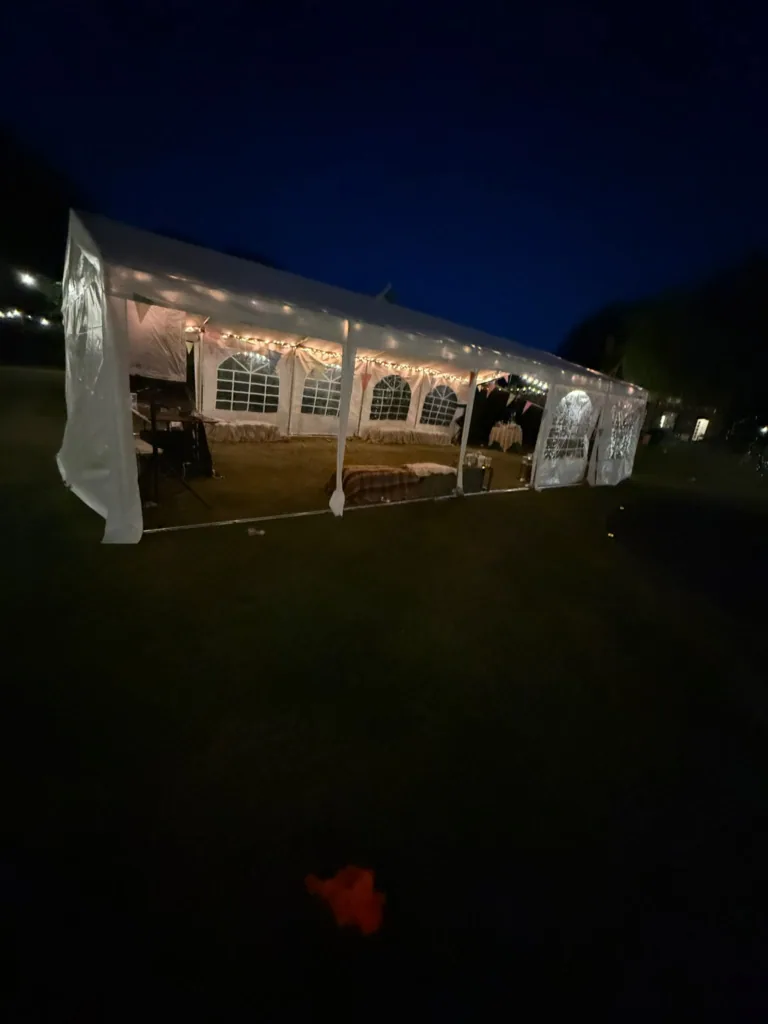Windowed marquee lit from inside at night, with festoon lighting