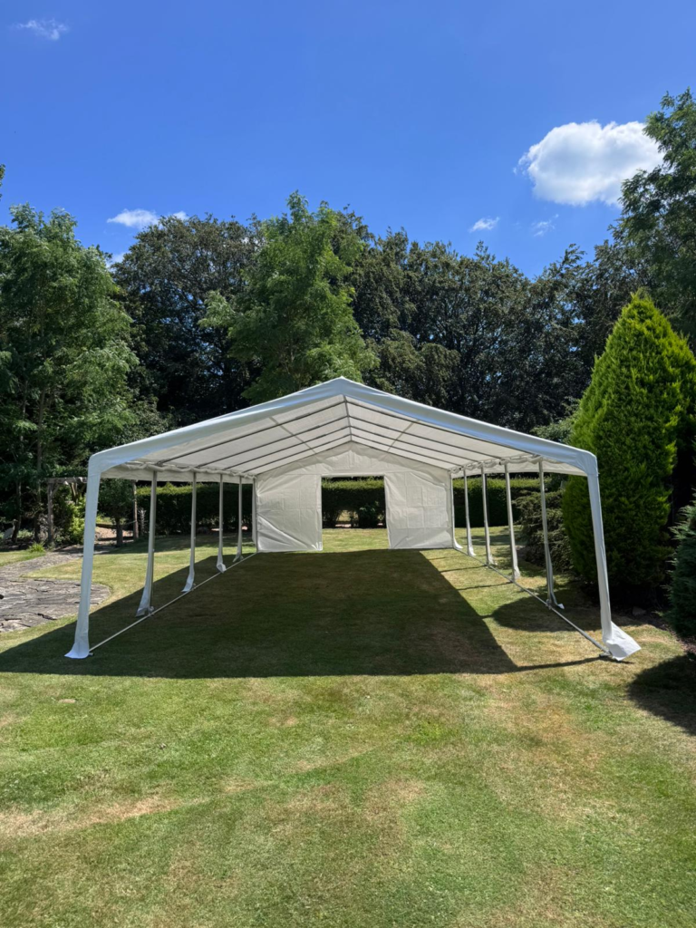Marquee with open sides on a garden lawn in summer
