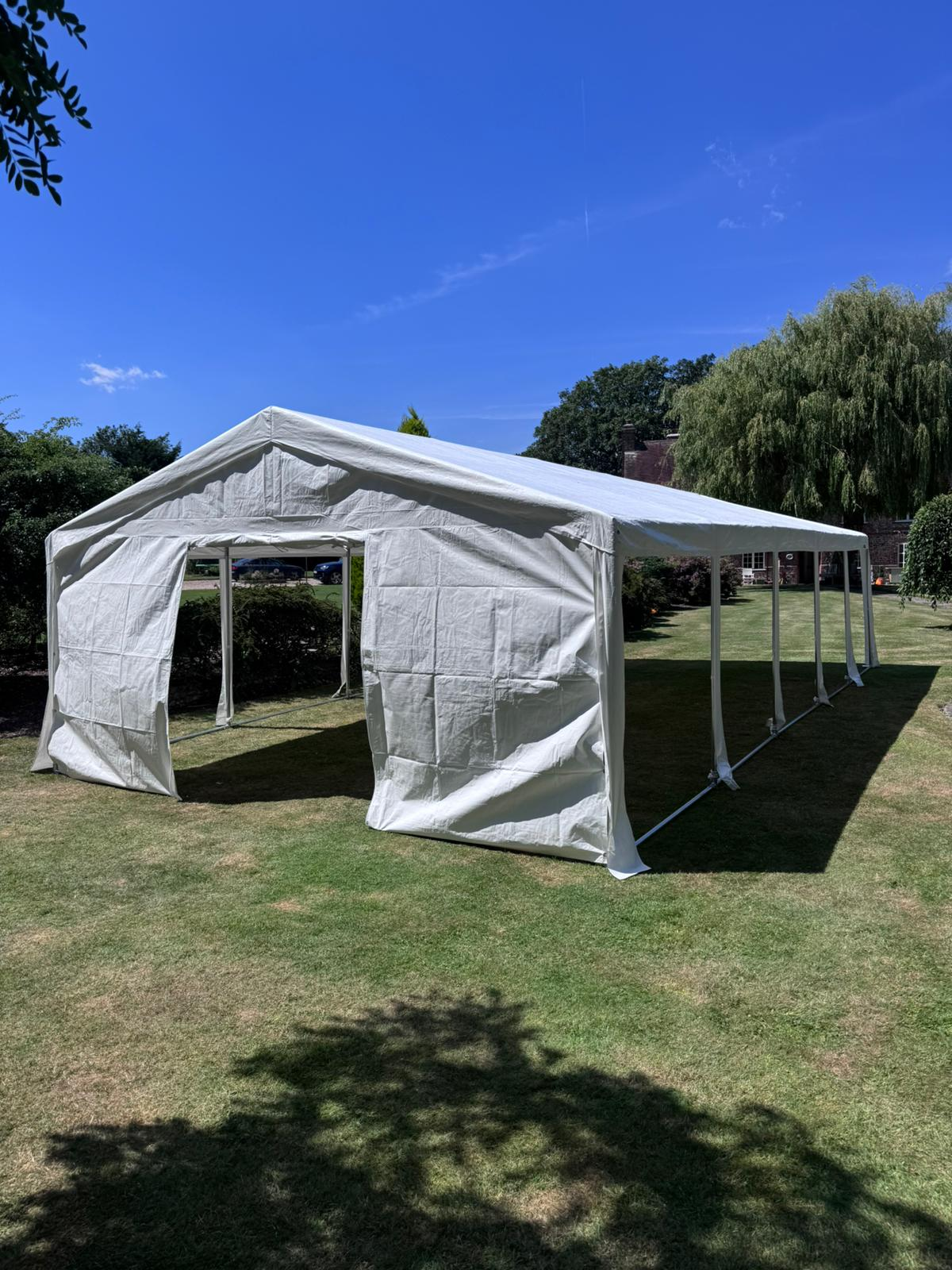 20m clear-span marquee with ivory lining and festoon lighting, set up for a wedding reception in Horsham