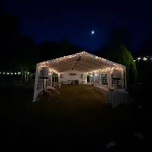 20m clear-span marquee with ivory lining and festoon lighting, set up for a wedding reception in Horsham