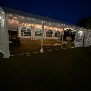 20m clear-span marquee with ivory lining and festoon lighting, set up for a wedding reception in Horsham