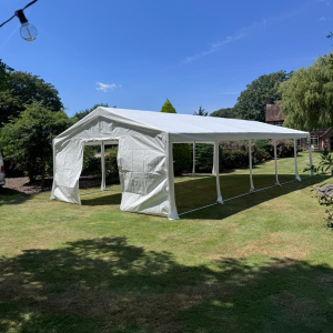 20m clear-span marquee with ivory lining and festoon lighting, set up for a wedding reception in Horsham